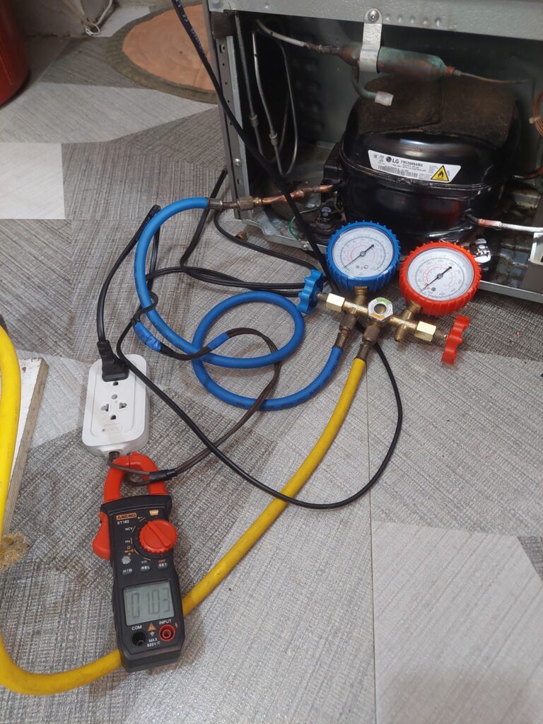 Manifold gauge set connected to LG refrigerator sealed system during diagnostic